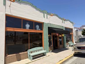 Long Beach apartment for rent - A storefront with a green bench in front of it.