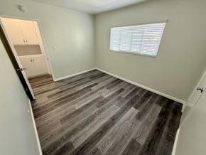 Long Beach apartment for rent - A room with wooden flooring and a window with blinds.