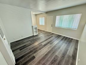 Long Beach apartment for rent - A room with wooden flooring and a white door.