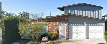 Long Beach apartment for rent - A house with a garage door and a sign in front of it.