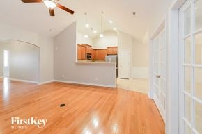 Winston Salem house for rent - A spacious room with wooden floors and a ceiling fan.