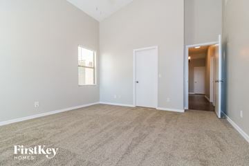 Buckeye house for rent - a spacious living room with carpet and a hallway to a bedroom
