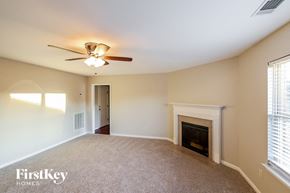 Bessemer house for rent - an empty living room with a fireplace and a ceiling fan