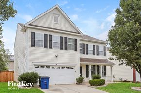 Winston Salem house for rent - A two-story house with a white garage door and a blue trash bin in front.