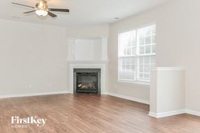Winston Salem house for rent - A living room with a fireplace and a ceiling fan.