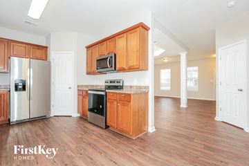 Winston Salem house for rent - A kitchen with wooden cabinets and a stainless steel refrigerator.