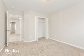 Winston Salem house for rent - A spacious room with a carpeted floor and white walls, with a doorway leading to another room.