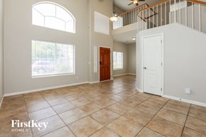 Mesa house for rent - A spacious room with a tiled floor and a staircase with a railing.
