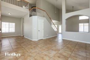 Mesa house for rent - A spacious living room with a staircase and a large window.