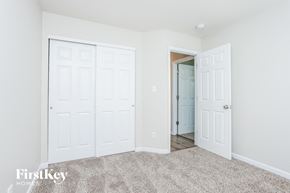 Wentzville house for rent - a bedroom with two closets and a door to a hallway