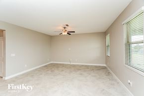 Ruskin house for rent - A spacious room with a ceiling fan and a window with blinds.