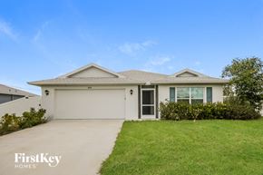 Cape Coral house for rent - a white house with a lawn and a driveway