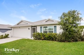 Cape Coral house for rent - a white house with a lawn and a garage