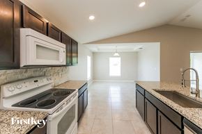 Cape Coral house for rent - a kitchen with a stove and a sink and a microwave