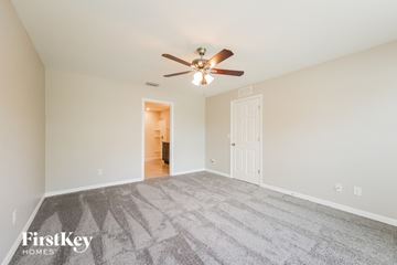 Cape Coral house for rent - a spacious living room with carpet and a ceiling fan
