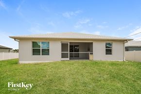 Cape Coral house for rent - the exterior of a house with a lawn and a grassy yard