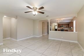 San Antonio house for rent - an empty living room with a ceiling fan and a kitchen