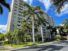 Waipahu apartment for rent - a large building with palm trees in front of it