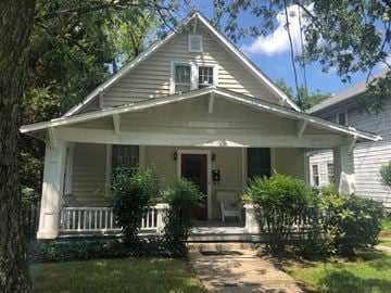 Greensboro apartment for rent - a white house with a porch with a white rocking chair on it