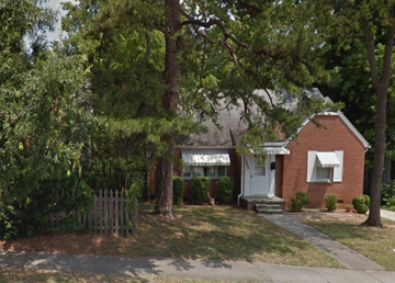 Greensboro apartment for rent - a small red brick house with trees in front of it