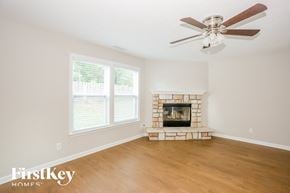 Concord house for rent - a living room with a fireplace and a ceiling fan