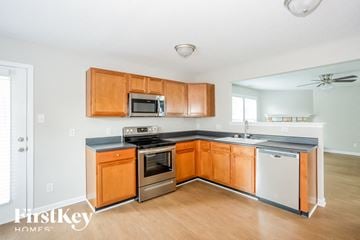 Concord house for rent - a kitchen with wooden cabinets and stainless steel appliances