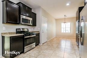 Buckeye house for rent - A kitchen with black cabinets and a granite countertop.
