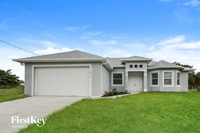 Lehigh Acres house for rent - a white house with a lawn and a garage