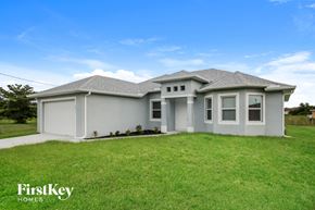 Lehigh Acres house for rent - a brand new house with a lawn in front of it