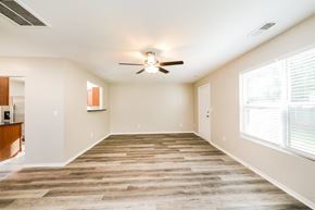 Winston Salem house for rent - an empty living room with a ceiling fan and large windows