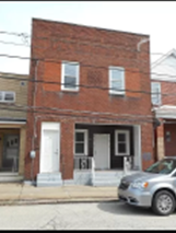 Clairton house for rent - A red brick building with a white door and windows.