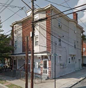 Trenton apartment for rent - A white house with a brown door and a brown fence.