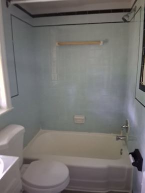 Trenton apartment for rent - A white toilet sits next to a bathtub in a small bathroom.