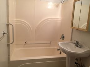 Windsor house for rent - A white bathroom with a sink, mirror, and bathtub.