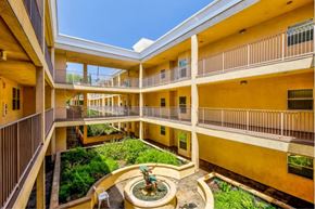 Sherman Oaks apartment for rent - a courtyard with a fountain in the middle of a yellow building