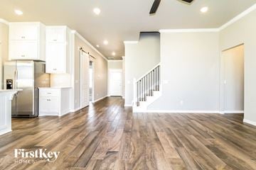 Edmond house for rent - A spacious kitchen with white cabinets and a wooden floor.
