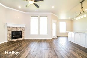 Edmond house for rent - A spacious living room with a fireplace and wood flooring.