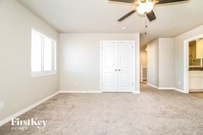 Edmond house for rent - A spacious room with a ceiling fan and a carpeted floor.