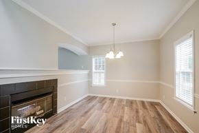 King house for rent - A room with a fireplace and wooden floors.
