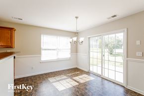 Gastonia house for rent - a dining room with a large window and a door to the backyard