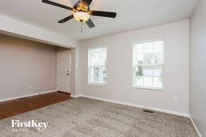 Wentzville house for rent - A room with a ceiling fan and two windows.
