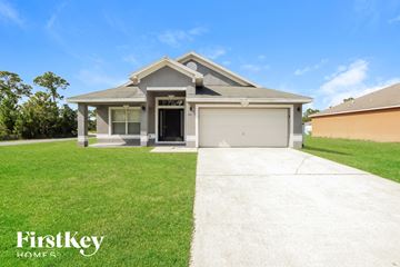 Palm Bay house for rent - a house with a lawn and a driveway