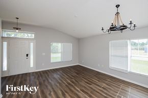 Palm Bay house for rent - an empty living room with a chandelier and windows