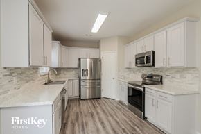Charlotte house for rent - a kitchen with white cabinets and stainless steel appliances