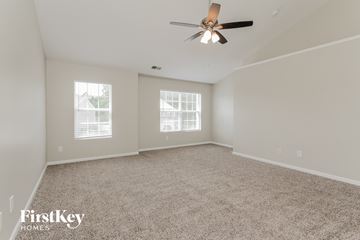 Charlotte house for rent - a spacious living room with carpet and a ceiling fan
