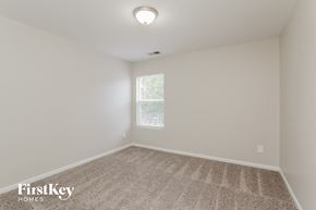 Charlotte house for rent - a bedroom with white walls and carpet and a window