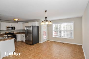 Clarksville house for rent - a kitchen with white cabinets and a stainless steel refrigerator