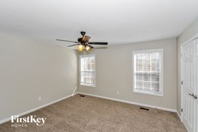 Clarksville house for rent - a bedroom with a ceiling fan and a carpeted floor