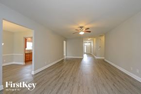 Kernersville house for rent - an empty living room with a ceiling fan and wood flooring