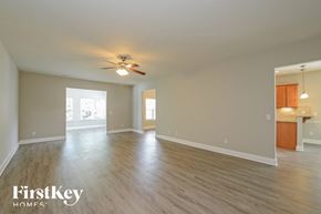 Kernersville house for rent - an empty living room with wood floors and a ceiling fan